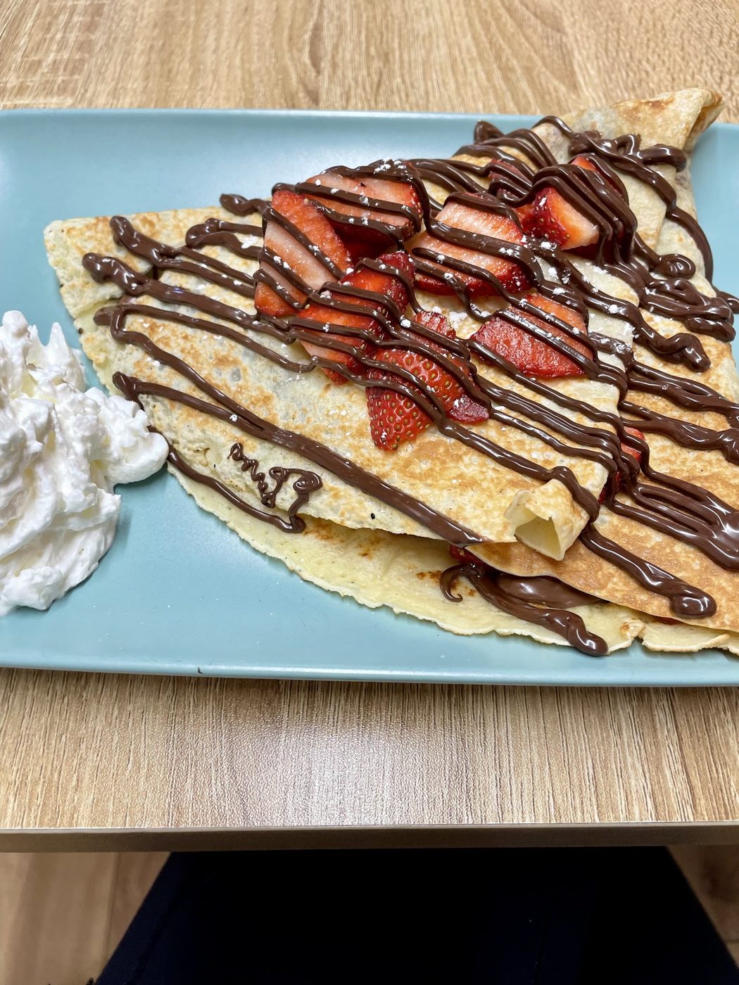 A crêpe with strawberries and chocolate sauce