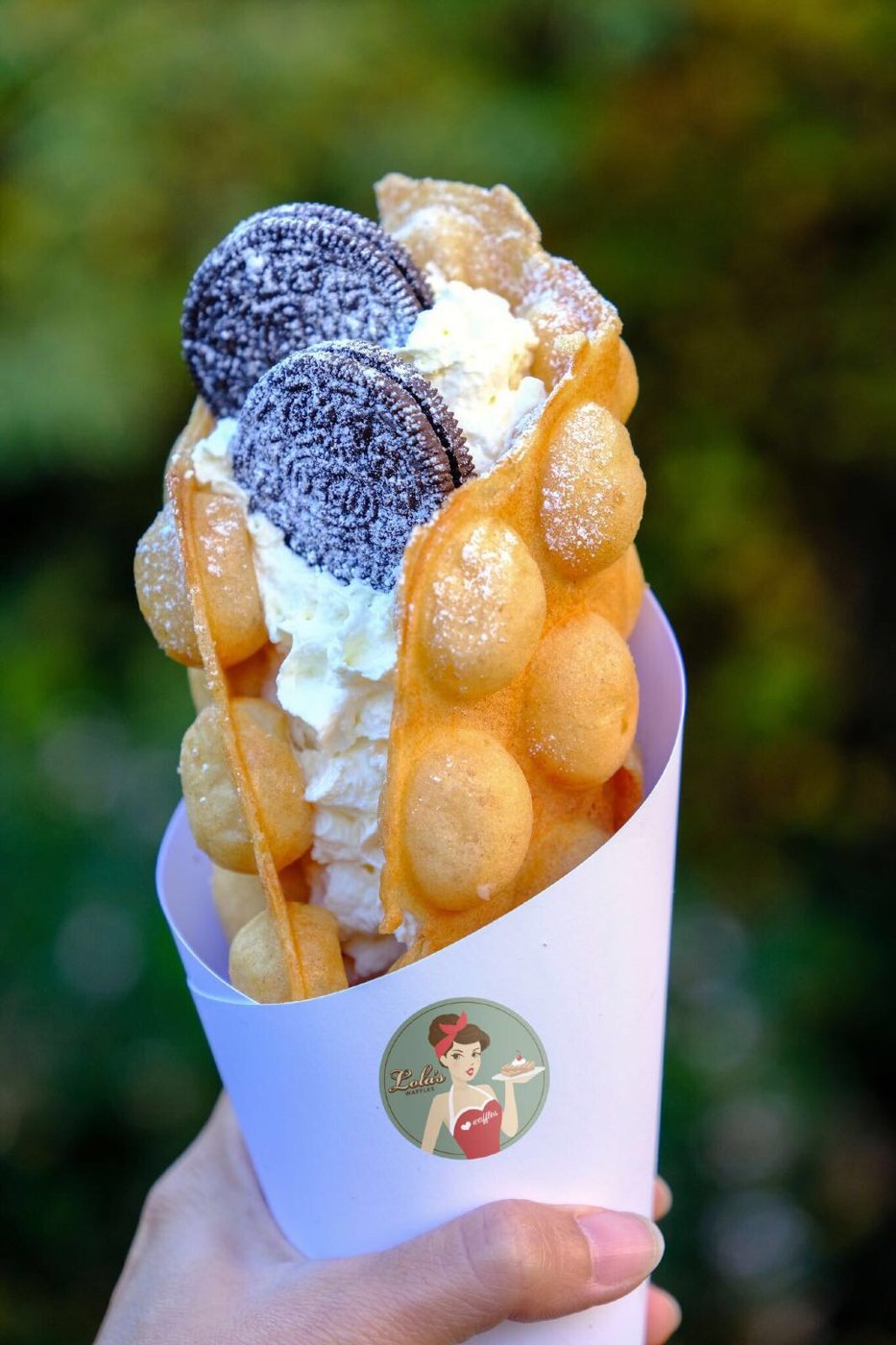 A bubble waffle cone topped with Oreos and cream